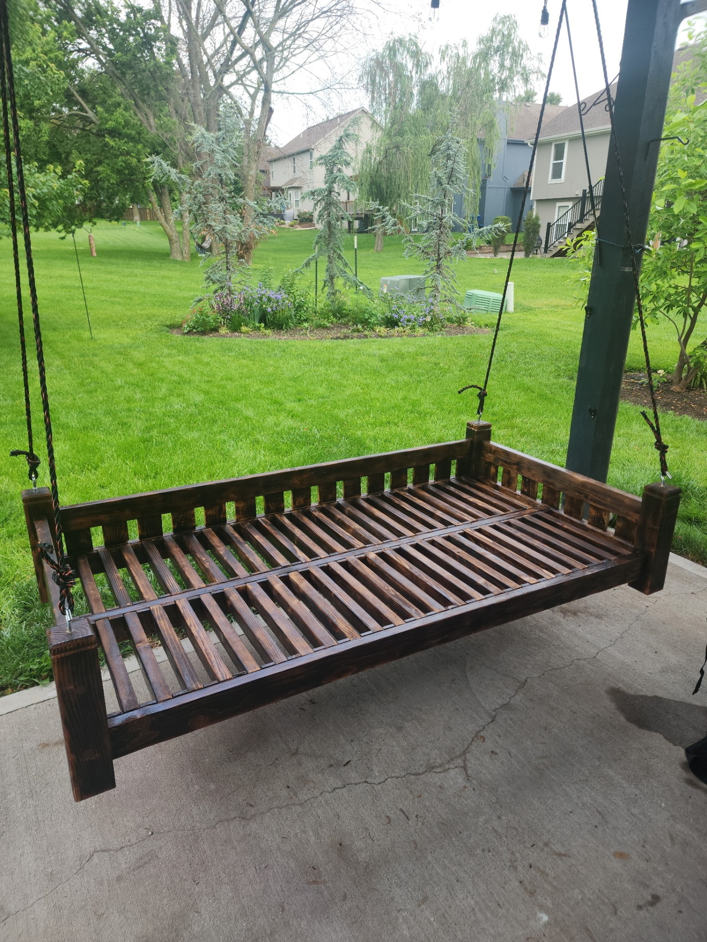 Hanging daybed suspended from outdoor frame
