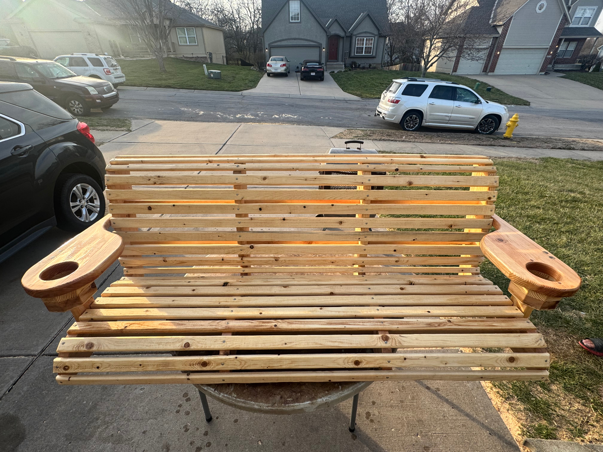 Porch swing mounted on outdoor stand in backyard